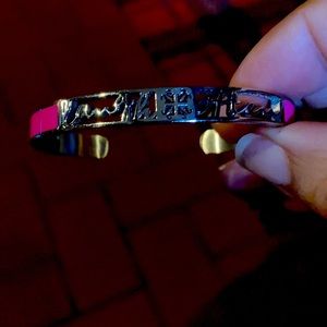 Hot pink slim rustic cuff bracelet that says “laugh often”